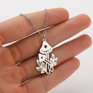 Detail shot of silver mushroom pendant with hollow star and moon patterns on a chain