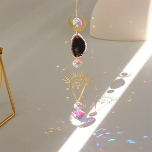 Detail of hanging suncatcher with agate slice and crystal prism casting rainbow light