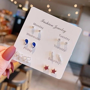 Detailed set of 7 pairs of assorted earrings featuring hearts and bows on display card
