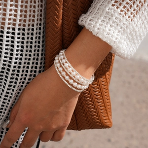 Detailed view of layered pearl and rhinestone bracelet with elegant silver finish