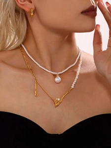 Detail of layered freshwater pearl necklace with gold liquid metal charm on model