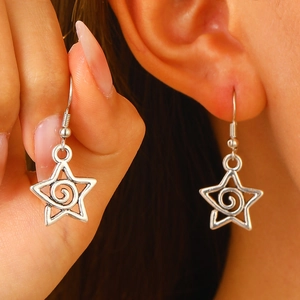 Boucles d'oreilles étoile argentées punk avec spirale et détails à pointes sur mannequin
