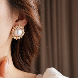 Gros plan détaillé d'une boucle d'oreille vintage fleur de soleil avec perles et strass