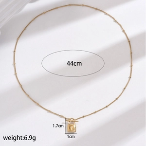 Detailed view of golden lock pendant necklace with dimensions 1.7cm by 1cm and 44cm chain