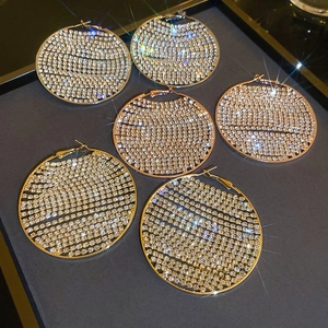 Detailed macro view of large geometric hoop earrings with high-density rhinestone inlay