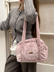 Vue détaillée d'un sac cabas rose léopard en fausse fourrure avec plaque logo bronze