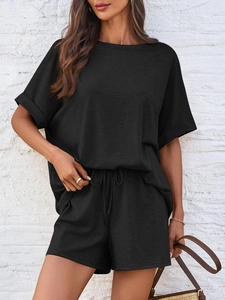 Detail der schwarzen Waffelstrick-Textur am Oversize-T-Shirt und der Tunnelzug-Shorts