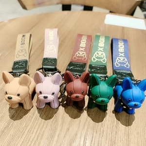 French Bulldog keychains in five colors displayed on a wooden surface