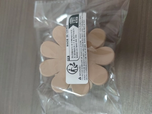 Flower-shaped beige hair claw clip packed in a transparent protective plastic bag