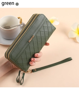 Detail of green quilted leather wallet with double zippers and detachable wristlet