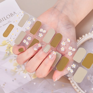 Detail showing daisy patterns and green nail stickers on a sheet with elegant pearls
