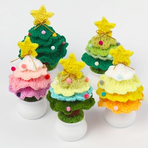 Close-up of handmade crochet Christmas tree ornaments in colorful yarn pots