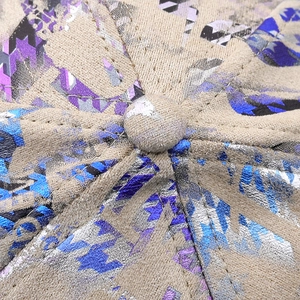 Makrodetail der beige Baseballkappe mit metallischem geometrischem Hahnentrittmuster