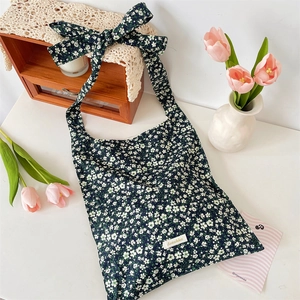 Détail du sac cabas en toile fleurie avec grand nœud d'épaule et étiquette tissée Sosakka