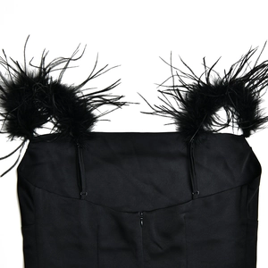 Détail d'une robe noire montrant les plumes aux épaules et la fermeture éclair au dos