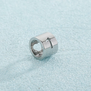Macro shot of silver stainless steel cylinder bead with engraved cross for DIY jewelry