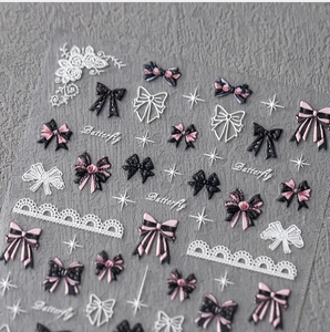 Macro detail of 3D embossed pink bow nail stickers with lace and butterfly designs