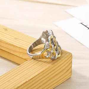 Détail d'une bague bicolore or et argent avec texture tressée sur un cadre en bois