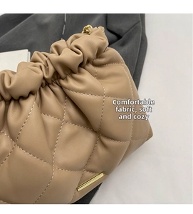 Detailed close-up of quilted leather texture and golden metal accents on khaki bucket bag