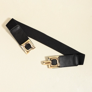 Detail of a black elastic waist belt featuring a polished gold geometric metal buckle