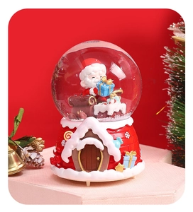 Detail of Christmas crystal ball with Santa Claus inside on a red house-shaped base