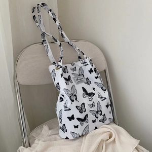 Detailed close-up of a butterfly print canvas tote bag featuring Augur brand label