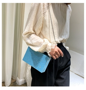 Blue glitter box bag with silver chain strap shown as a stylish crossbody evening purse