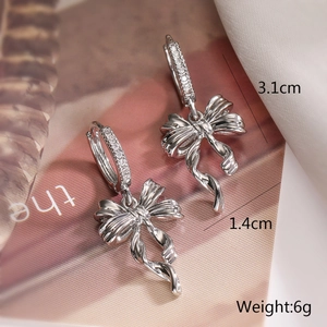 Detailed view of silver bow drop earrings showing 3.1cm height and 1.4cm width dimensions