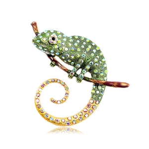 Vintage green chameleon lizard brooch with colorful rhinestones on a brown branch