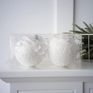 Two white petal Christmas balls with glitter finish and silver loops in a clear box