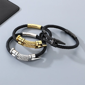 Close-up of punk style stainless steel cable bracelets in gold silver and black
