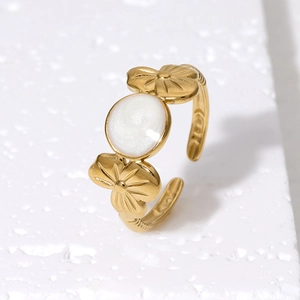 Adjustable gold flower ring with mother-of-pearl stone on white stone background