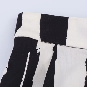 Primer plano detallado del estampado de rayas abstractas blancas y negras en falda midi