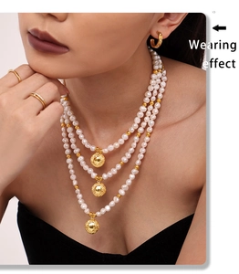 Three-layer freshwater pearl necklace with gold hollowed spherical pendants on model