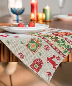 Detailed weave of Christmas table runner with red reindeer and gift patterns