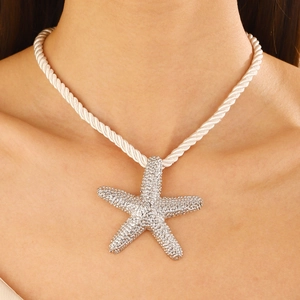 Detail of starfish pendant necklace with white rope chain and sparkling rhinestones