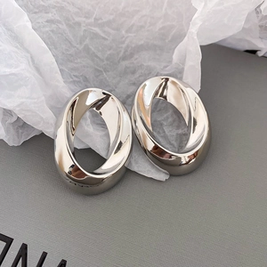 Macro shot of polished silver twisted oval earrings showing high mirror finish surface