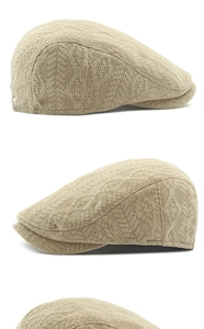 Detailed close-up of beige knitted newsboy cap featuring silver side buckle and ribbed texture