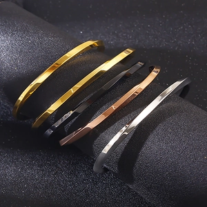 Detail of twisted stainless steel C-bracelets in gold, silver, black and rose gold finishes