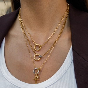 Close-up of triple-layered 18K gold stainless steel chain with ring clasp and cross pendant