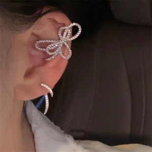 Elegant silver butterfly ear cuff with sparkling rhinestones worn on a model's ear