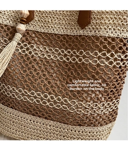 Detail of woven mesh pattern and brown leather handle with wooden bead tassel on straw bag