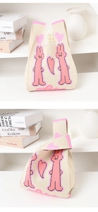 Detail view of knitted tote bag with cute pink rabbits and hearts on beige fabric
