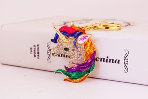 Detailed macro of unicorn keychain featuring colorful enamel mane and sparkling rhinestones