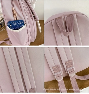 Detail view showing side pockets, padded straps, and handle of this purple school backpack