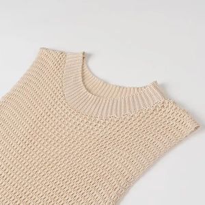 Détail de la texture en maille ajourée beige et col rond côtelé sur robe sans manches