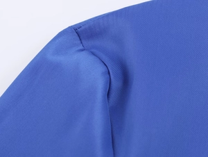 Detailansicht der blauen Faltenbluse mit feinen Nähten und glatter Stofftextur