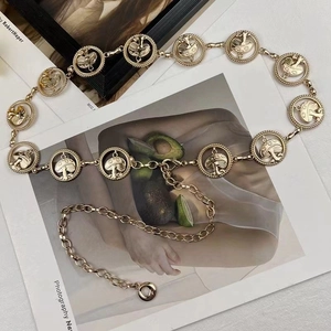 Detail of gold metal chain belt with circular hollow mushroom links and adjustable clasp