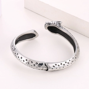 Bracelet léopard en argent poli avec taches noires dans un décor minimaliste chic