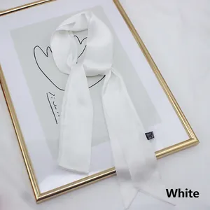 Elegant long white satin scarf tied on a gold frame, minimalist French style accessory